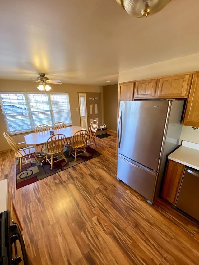 kitchen with ceiling fan, stainless steel appliances, and hardwood / wood-style flooring