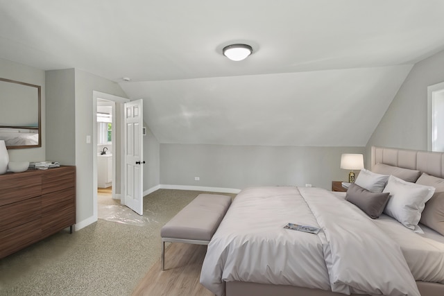 bedroom with light hardwood / wood-style floors and lofted ceiling