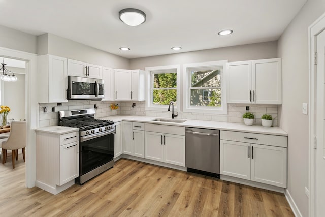 kitchen featuring tasteful backsplash, white cabinetry, sink, and appliances with stainless steel finishes