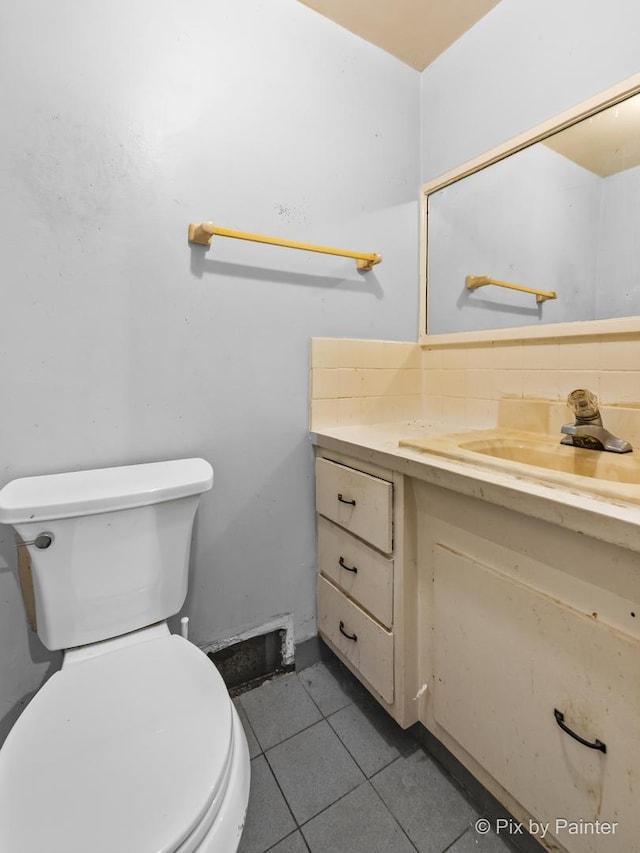 bathroom featuring tile patterned floors, vanity, toilet, and decorative backsplash