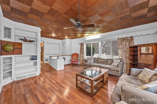 living room with ceiling fan, light hardwood / wood-style floors, wood ceiling, and wooden walls