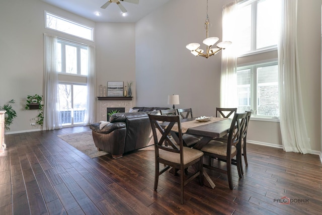 dining area featuring a towering ceiling, dark wood-type flooring, and a wealth of natural light