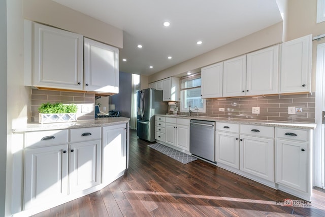 kitchen featuring white cabinetry, appliances with stainless steel finishes, dark hardwood / wood-style flooring, and light stone counters