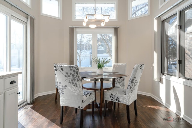 dining room featuring a high ceiling, dark hardwood / wood-style floors, and a wealth of natural light