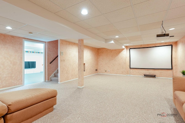 carpeted home theater room featuring a paneled ceiling