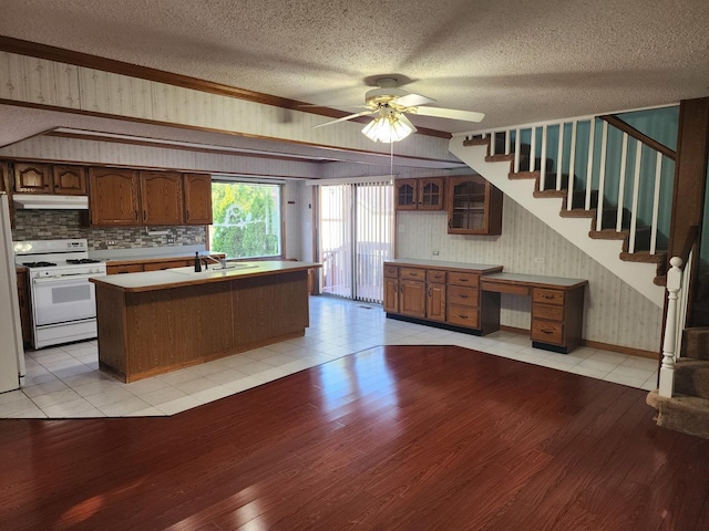 kitchen with ceiling fan, sink, a textured ceiling, white appliances, and a kitchen island