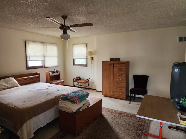 carpeted bedroom with a textured ceiling and ceiling fan