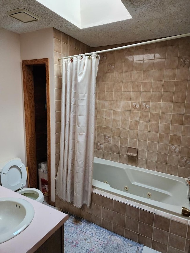 full bathroom with shower / bath combo with shower curtain, vanity, a textured ceiling, and toilet