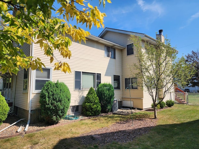 rear view of property with a lawn