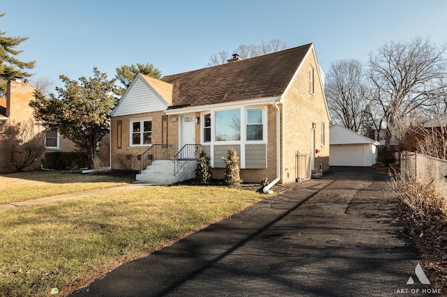 view of front of house featuring a front yard, a garage, and an outdoor structure