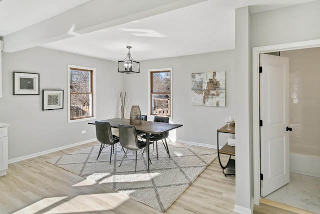 dining room with light hardwood / wood-style floors and a notable chandelier