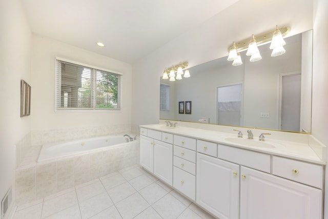 bathroom featuring tile patterned floors, vanity, and tiled bath