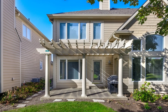 rear view of house featuring a pergola, cooling unit, and a patio area