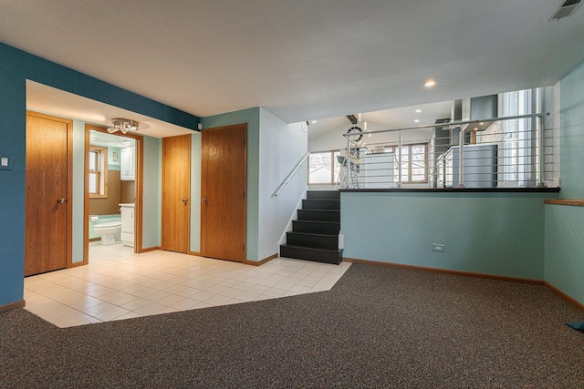 carpeted spare room featuring plenty of natural light and lofted ceiling