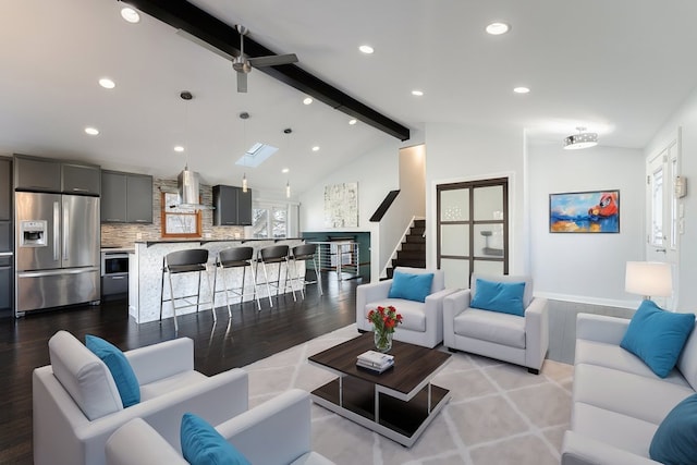 living room with vaulted ceiling with skylight and light hardwood / wood-style floors