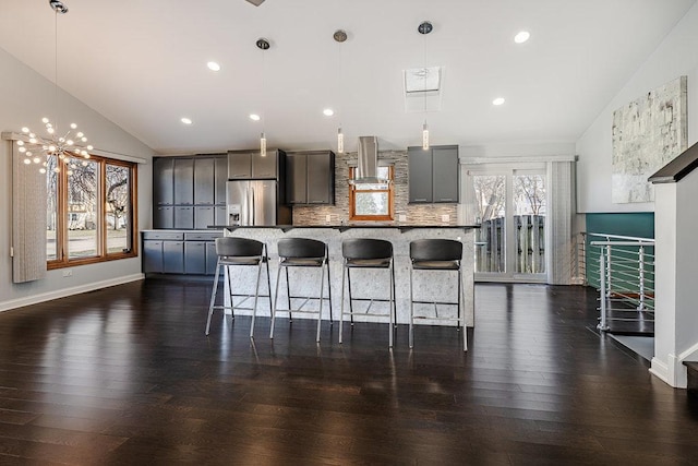 kitchen featuring gray cabinetry, stainless steel fridge with ice dispenser, extractor fan, decorative light fixtures, and decorative backsplash