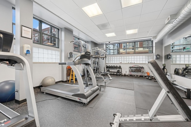 gym featuring a paneled ceiling and plenty of natural light