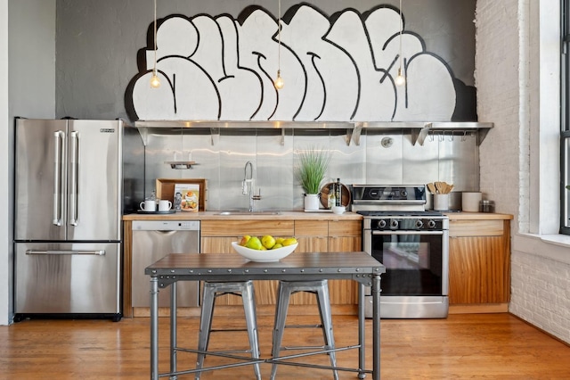 kitchen with sink, stainless steel appliances, and light hardwood / wood-style flooring