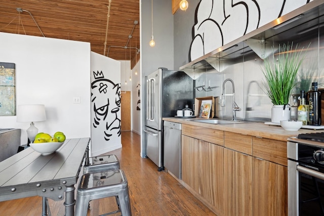 kitchen with sink, wooden counters, hardwood / wood-style floors, wood ceiling, and appliances with stainless steel finishes