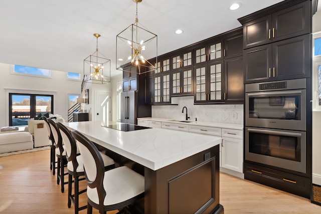 kitchen with pendant lighting, a breakfast bar, sink, a kitchen island, and stainless steel appliances