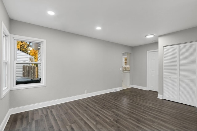 unfurnished bedroom featuring a closet and dark hardwood / wood-style floors