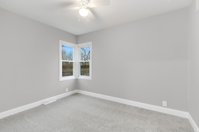 carpeted spare room featuring ceiling fan