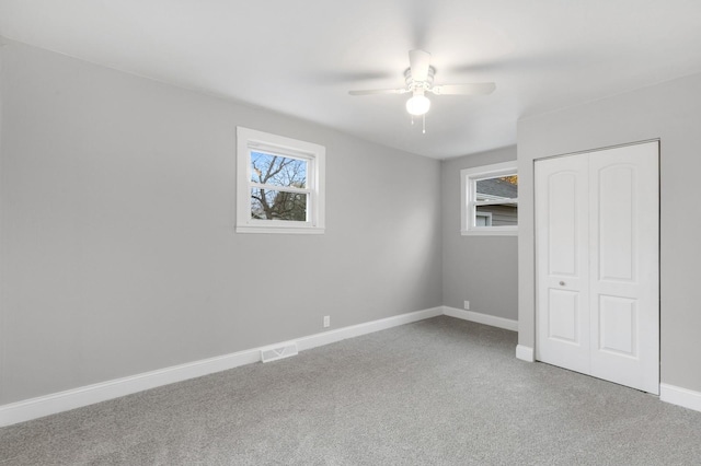 unfurnished bedroom with carpet, a closet, and ceiling fan