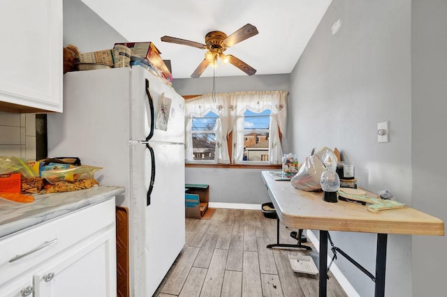 kitchen with white refrigerator, ceiling fan, tasteful backsplash, light hardwood / wood-style floors, and white cabinetry