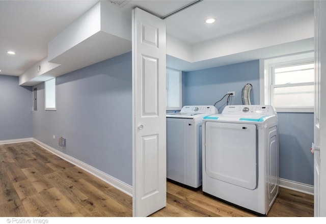 washroom with separate washer and dryer and light hardwood / wood-style floors