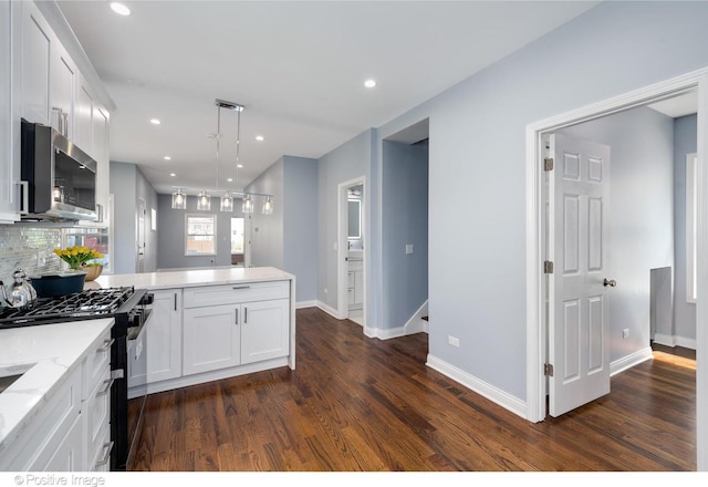 kitchen featuring black gas range, white cabinets, decorative backsplash, decorative light fixtures, and dark hardwood / wood-style flooring