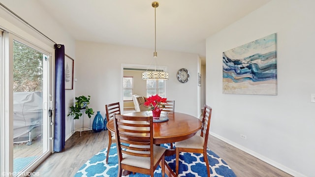 dining space featuring light wood-type flooring and a healthy amount of sunlight