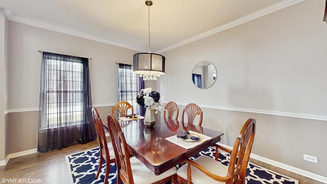 dining space with hardwood / wood-style flooring and crown molding