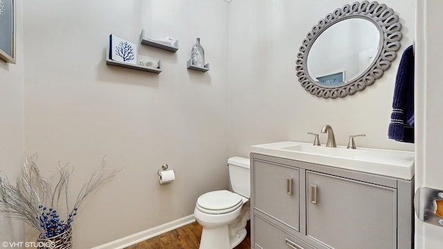 bathroom featuring vanity, hardwood / wood-style flooring, and toilet