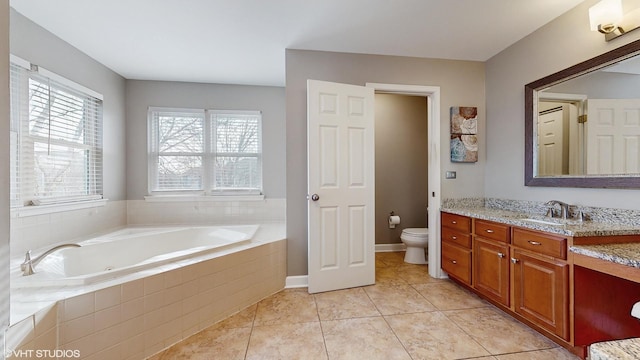 bathroom featuring tile patterned floors, vanity, toilet, and tiled tub