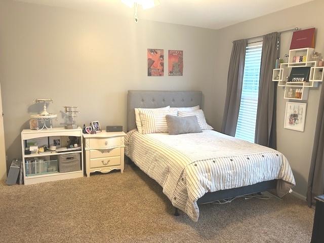 bedroom featuring ceiling fan, ensuite bathroom, and light carpet