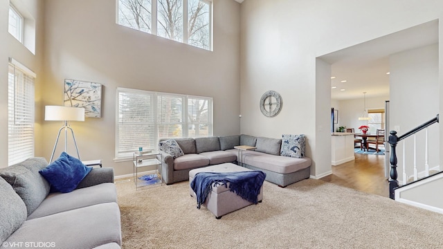 living room with carpet flooring and a towering ceiling