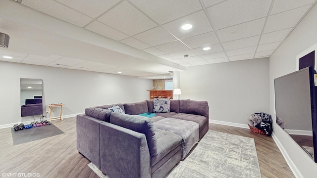 living room with wood-type flooring and a drop ceiling