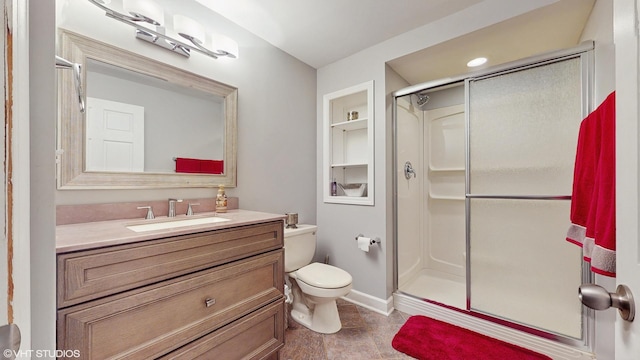 bathroom featuring built in shelves, vanity, toilet, and an enclosed shower