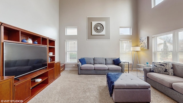 carpeted living room with a towering ceiling