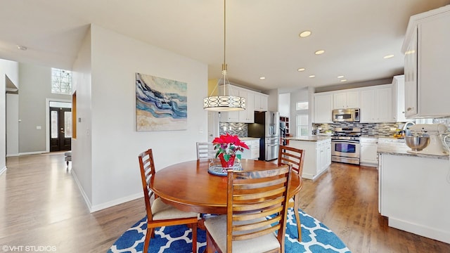 dining space featuring hardwood / wood-style floors, a healthy amount of sunlight, and sink