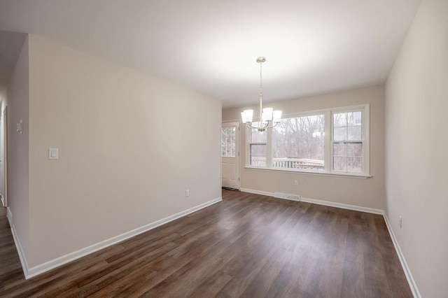 unfurnished dining area with dark wood-type flooring and a chandelier