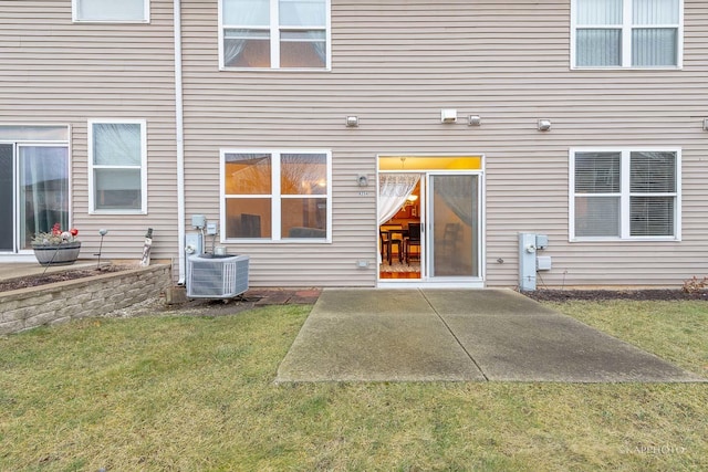 rear view of property featuring a yard, central AC, and a patio area