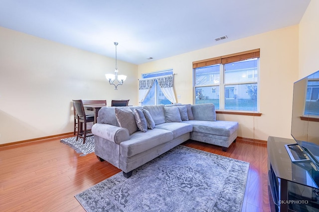 living room with wood-type flooring and a notable chandelier