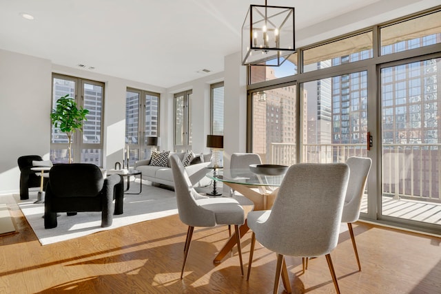 dining space with light hardwood / wood-style floors and a chandelier