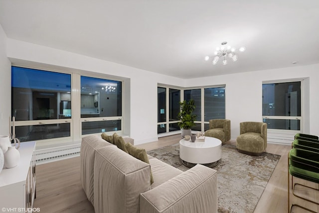 living room with light wood-type flooring and an inviting chandelier