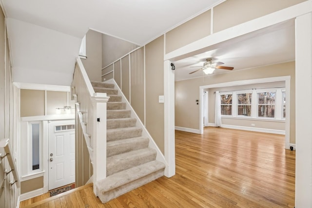 stairway featuring wood-type flooring and ceiling fan