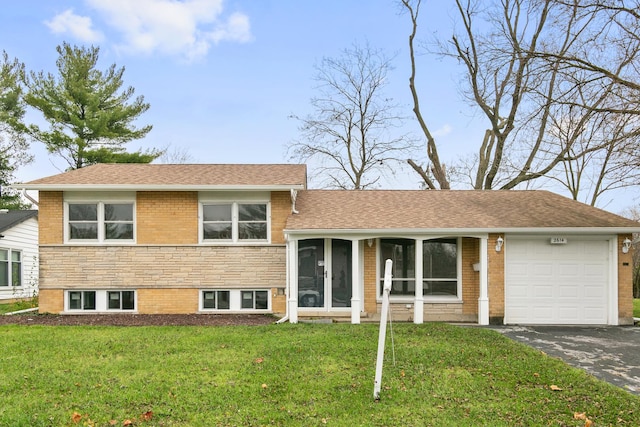 tri-level home with a garage, a front lawn, and a sunroom