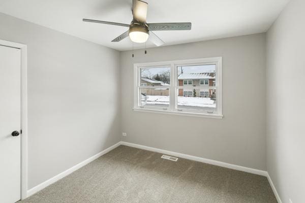 carpeted spare room with ceiling fan