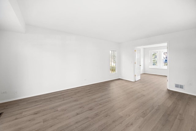 empty room featuring hardwood / wood-style flooring and french doors