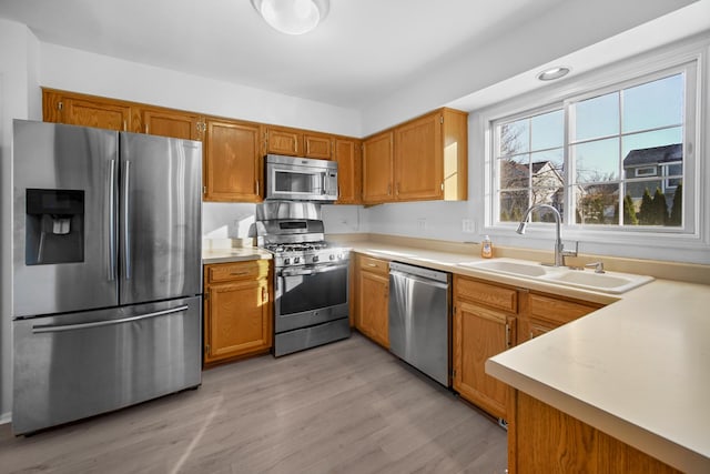 kitchen featuring appliances with stainless steel finishes, light hardwood / wood-style floors, and sink